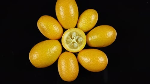 Bright Kumquats Arranged on a Black Surface