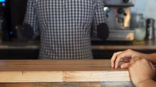 Le barista donne un ordre au client