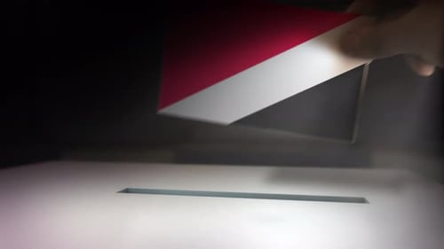 Hand Inserting Ballot Into Box for Election