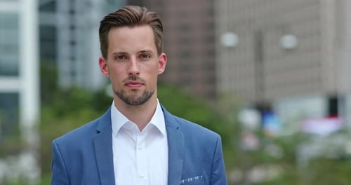 Handsome Man in Blazer Stands in Urban Setting