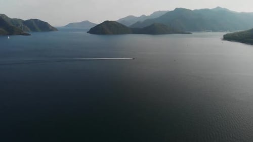 Boat Sailing From Left To Right on the Sea on the Background of Beautiful Islands. The Camera Rises
