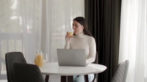 Woman Working Remotely at Table with Laptop