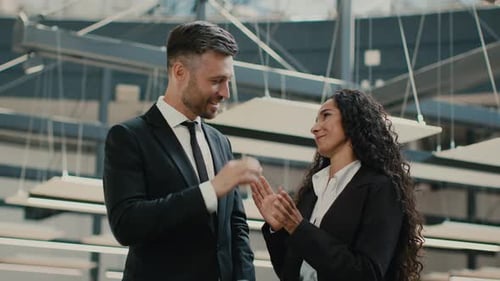 Male And Female Coworkers Talking Standing In Spacious Office
