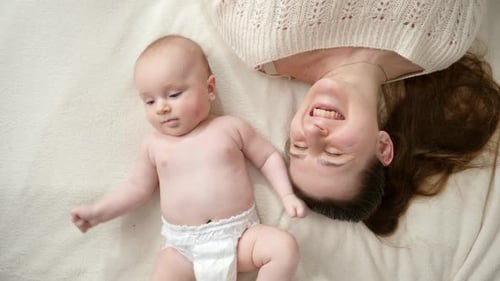 Happy Baby and Mother Lying on Blanket