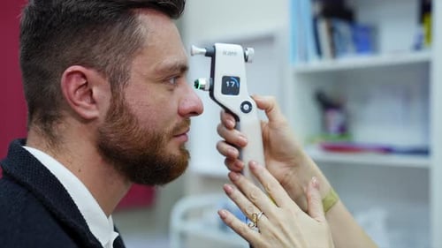 Arzt überprüft die Augen mit dem Gerät. Augenarzt überprüft das Sehvermögen eines jungen Mannes mit modernen Geräten