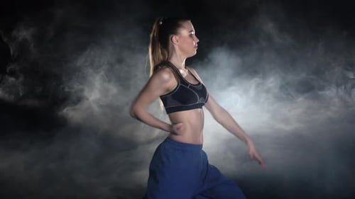 Woman Practicing Martial Arts in Smoky Studio