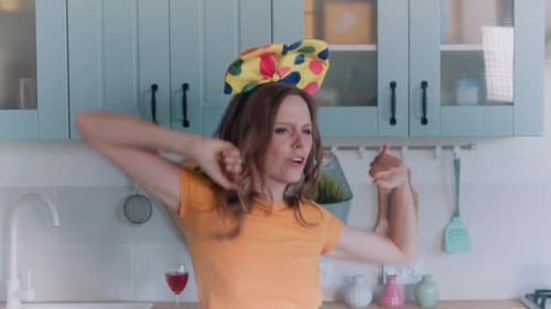Woman Dancing in Kitchen with Colorful Headband