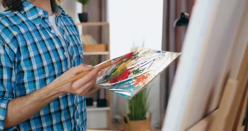 Young Artist Painting on a Canvas in Studio