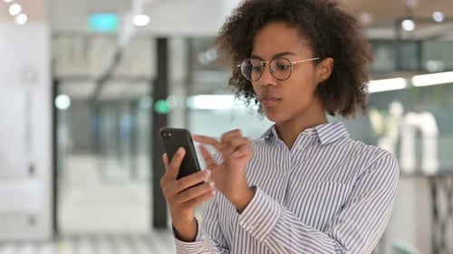 Woman Uses Smartphone in Modern Office Setting