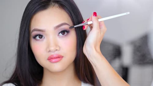 Woman Applying Eyeshadow With Brush Close Up
