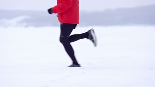 Adult Running Across a Snowy Winter Landscape