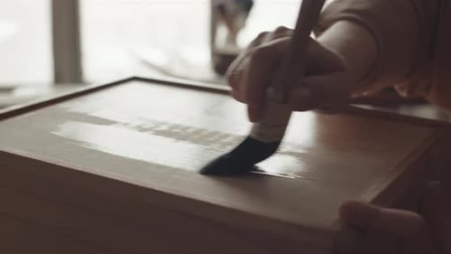 Carpintero pintando artesanía en madera