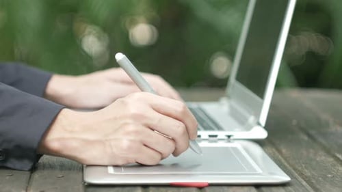 Digital Artist Using Drawing Tablet Outdoors