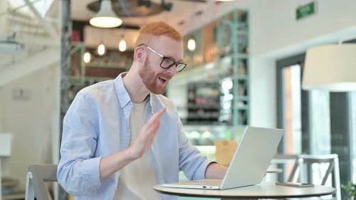 Video Chat on Laptop By Redhead Man in Cafe