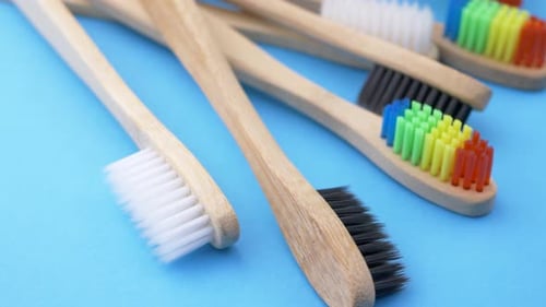 Wooden Toothbrushes on Light Blue Background