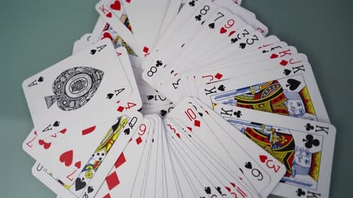 A deck of cards spread out on a table, close up spinning shot