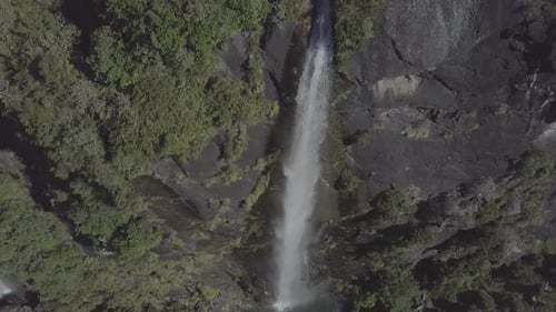 Aerial View of Tall Waterfall Cascading Down Cliff