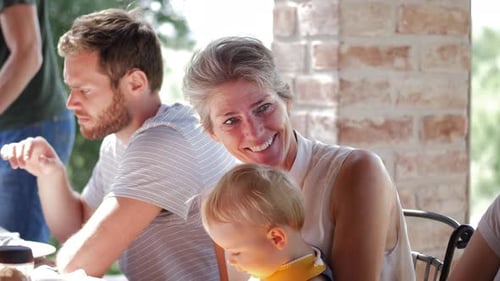 Three Generations of Family Eating Together Outdoors