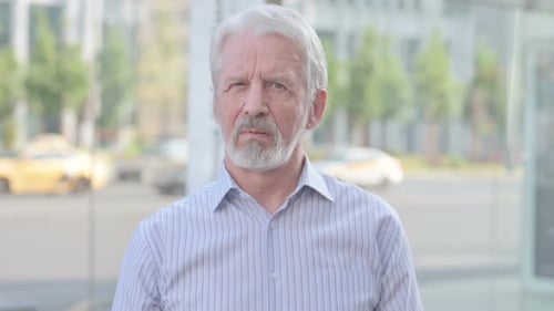 Senior Man Stares Forward in Urban Setting