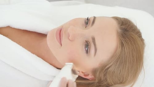 Frau mit einer stimulierenden Gesichtsbehandlung von einem Therapeuten
