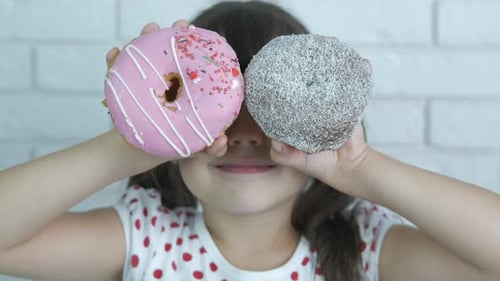 Cheerful kid with donuts.