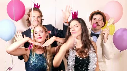 Group of young friends having a great time in party photo booth