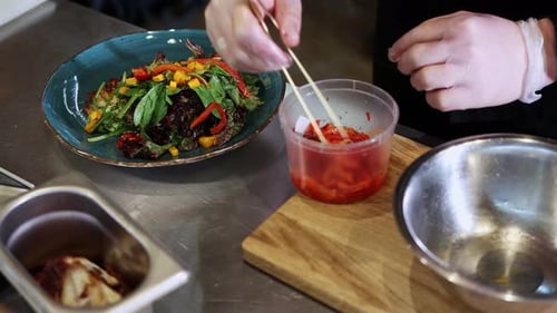 Chef Prepares a Colorful Salad with Chopsticks
