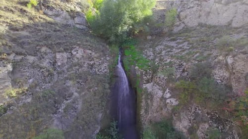 Aerial View of Waterfall Cascading Down Rocky Cliffs