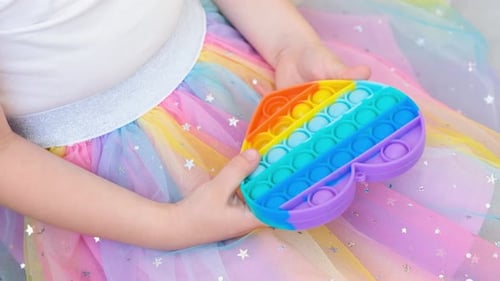 Child Playing with Colorful Pop-It Toy Indoors
