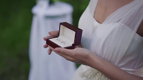 Woman Holding Wedding Rings in a Box