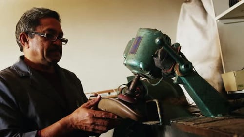 Artisan Repairs Shoe Using Vintage Machine