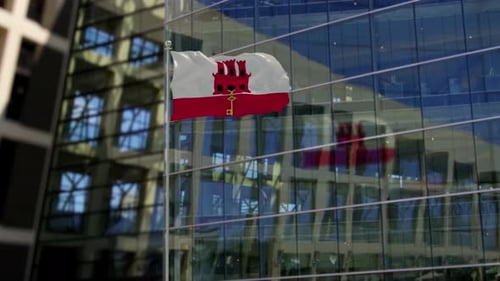 Gibraltar-Flagge weht auf einem Wolkenkratzer-Gebäude