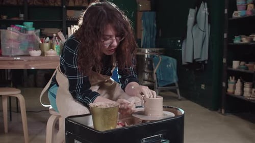 Woman Shaping Clay on Pottery Wheel in Studio