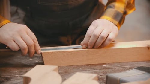 Woodworker Measuring Wood with Ruler and Marking Line