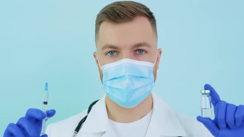 Medical Professional Holds Syringe and Vial Close Up