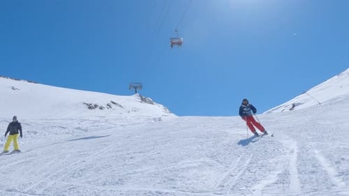 Skier Carving Down Snowy Mountain on a Sunny Day