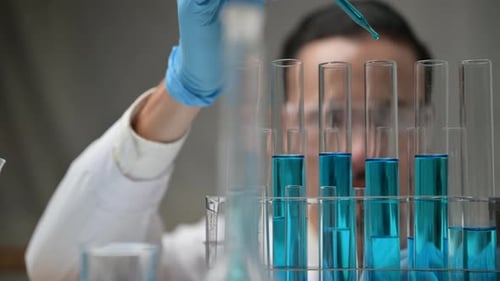 Scientist Working with Blue Liquid in Laboratory