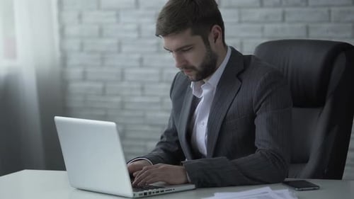 Man Working on Laptop in Modern Office