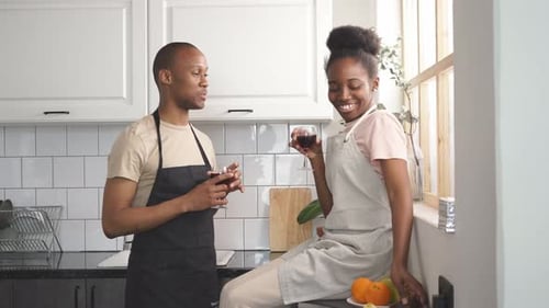 Young Couple Celebrate with Wine in Bright Kitchen