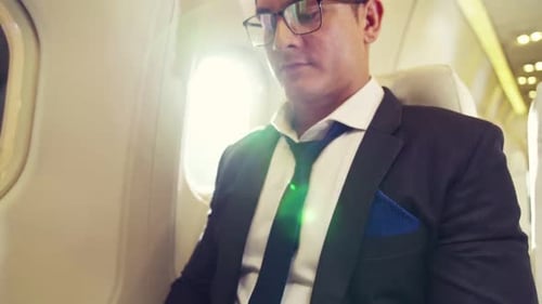 Businessman Working on Laptop During Airplane Flight