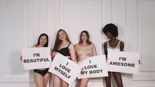 Quatre belles femmes tenant des pancartes avec des affirmations positives
