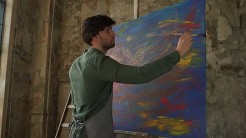 Male Artist Painting Picture in Studio