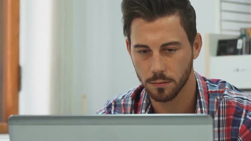 Young Adult Using Laptop at Office Desk