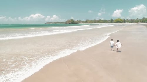 Couple Walking On A Sandy White Tropical Beach