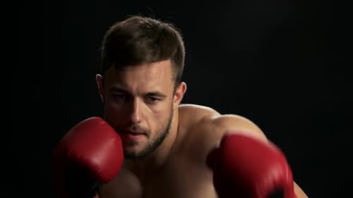 Intense Boxer Shadow Boxing with Red Gloves
