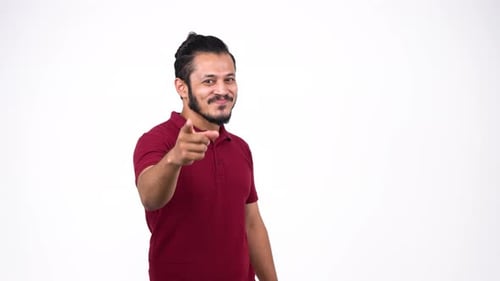 Happy young Indian man pointing towards the camera