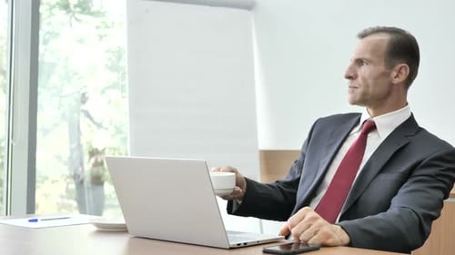 Executive Working on Laptop and Drinking Coffee