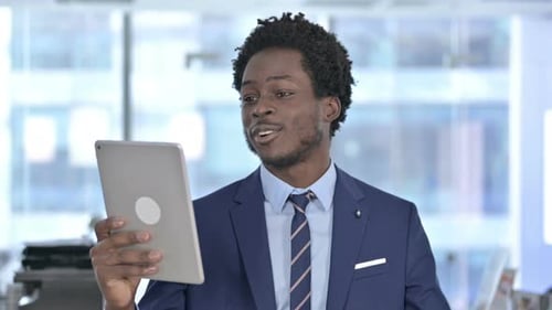Smiling Man Video Conferencing With Tablet in Office