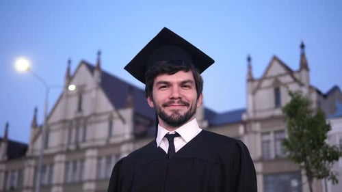 Attractive Smiling Male Graduate Standing and Looking at Camera.