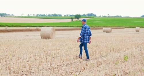 Farmer Using Digital Tablet While Examining Field